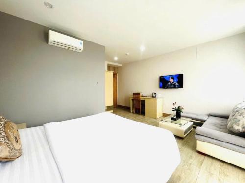 a bedroom with a bed and a couch at Hotel Hoài Bảo in Ấp Rạch Mẹo