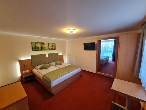 a hotel room with a bed and a balcony at Panorama Hof Sereinig in Sankt Oswald