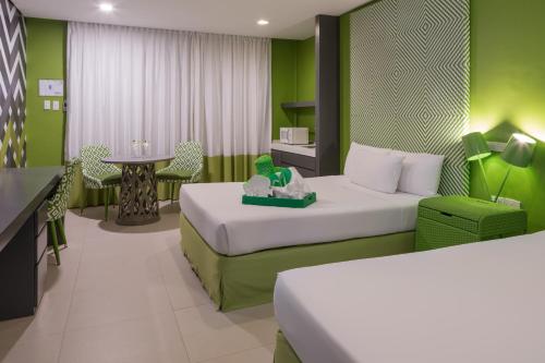 a hotel room with two beds and a table at Astoria Boracay in Boracay
