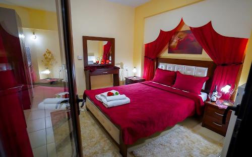 a bedroom with a red bed and a mirror at Relax pozar in Kato Loutraki
