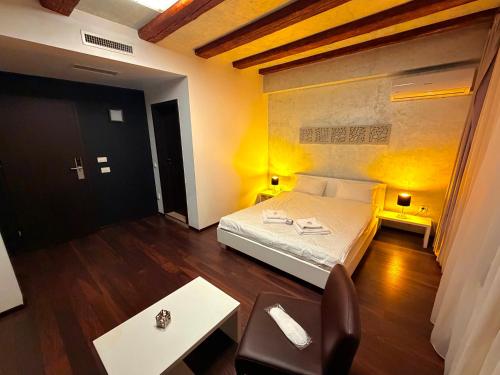 a bedroom with a bed and a table and a chair at Sibiutiful - Ultracentral in Sibiu