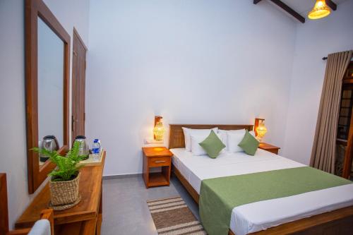 a hotel room with a bed and a mirror at The Clouds Ahangama in Ahangama