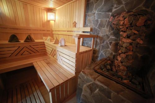 a wooden sauna with a stone fireplace in it at Сонячний Лаз in Polyana
