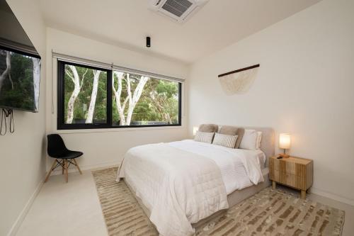 a white bedroom with a bed and a large window at The Hudson with Heated Pool in Rye