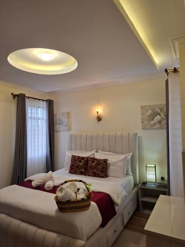 a bedroom with a bed with a basket on it at Pearl Apartment Ruaka in Ruaka