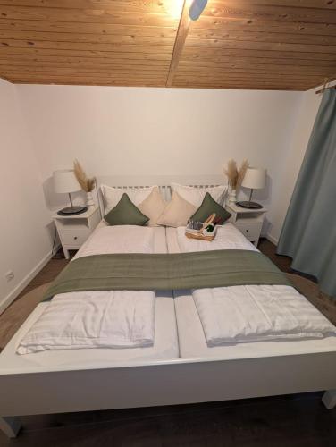 a bedroom with a large white bed with two night stands at KREIDESEE 47 - Hemmoor in Hemmoor