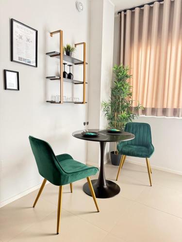 a table and two green chairs in a room at Luxury apartment - SUITE CAVOUR in Bari