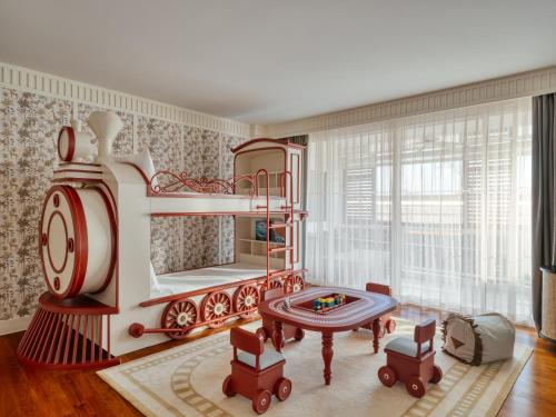 a childs bedroom with a red and white bed and a table at InterContinental Hua Hin Resort by IHG in Hua Hin