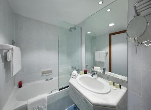 a white bathroom with a sink and a shower at Admiral Plaza Hotel in Dubai