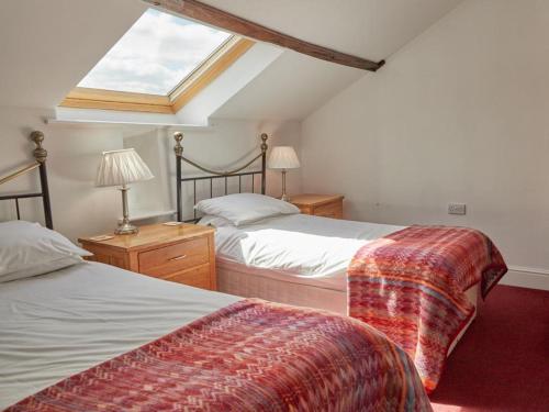 a attic bedroom with two beds and a skylight at 8 Bed in Cumbria oc-sz373 in Applethwaite