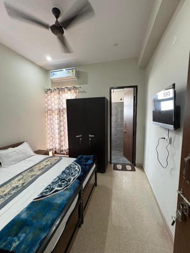a bedroom with a bed and a ceiling fan at Vansh Residency Couple Friendly Near Rajiv Chowk Gurgaon in Gurgaon