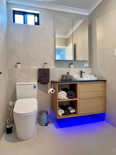 a bathroom with a toilet and a sink and a mirror at il Villinno on Dalton - Great Location in Mosman Park
