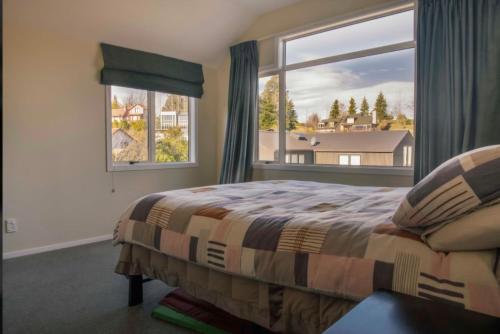 a bedroom with a bed and a large window at Cozy Escape in Wanaka