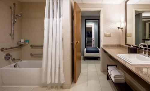 a bathroom with a tub and a toilet and a sink at Hyatt Regency Saint Louis at The Arch in Saint Louis