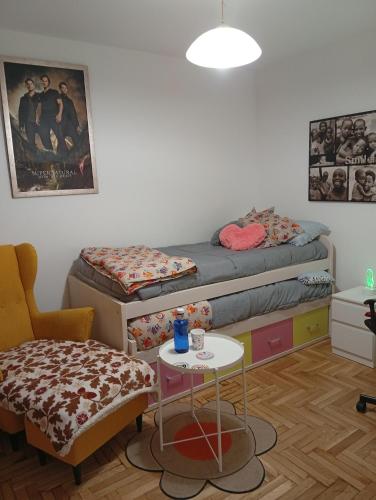 a room with two beds and a table and a chair at Ka'Luzy in Santa Ana