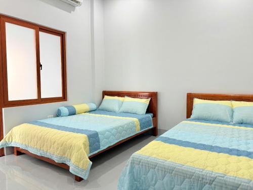 two beds sitting next to each other in a bedroom at HOMESTAY- Hưng Thịnh in Vạn Ninh