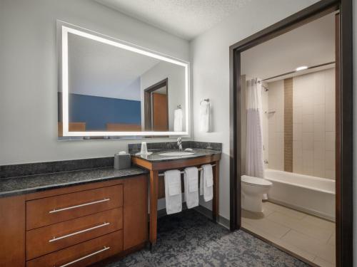 a bathroom with a sink and a toilet and a mirror at Hyatt Place Lakeland Center in Lakeland