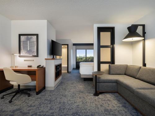 a living room with a couch and a desk at Hyatt Place Lakeland Center in Lakeland