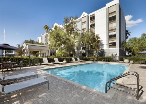 a swimming pool with lounge chairs and a building at Hyatt Place Lakeland Center in Lakeland