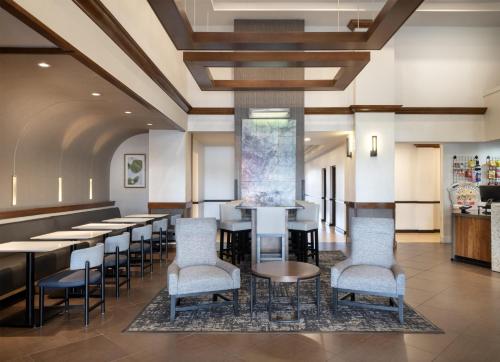 a restaurant with tables and chairs and a bar at Hyatt Place Lakeland Center in Lakeland