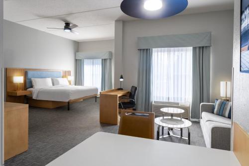 a hotel room with a bed and a couch at Homewood Suites by Hilton Rochester/Greece, NY in Rochester