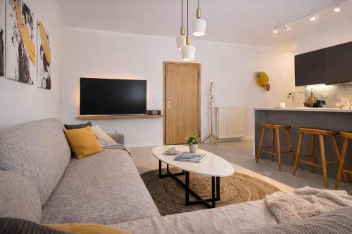 a living room with a couch and a table at A Comfortable Stay with Balcony and Easy Parking near Kalamata Center in Kalamata
