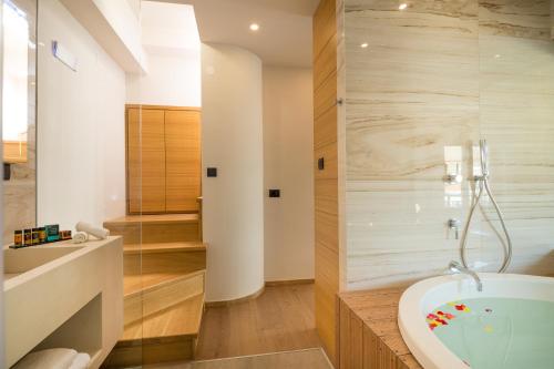 a bathroom with a tub and a sink at Querini Luxury Suites in Chania Town