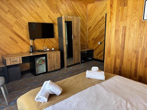 a bedroom with a bed with two towels on it at Şəki Yaylası Hotel in Sheki