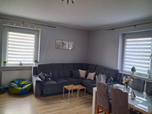 a living room with a blue couch and a table at Sowie Pokoje in Jugów