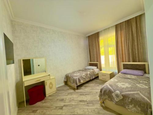a hotel room with two beds and a television at Qax home in Qax