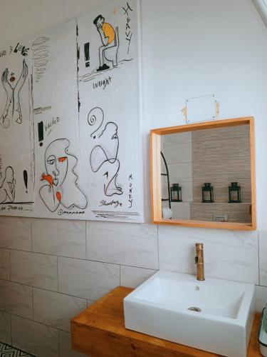 a bathroom with a sink and a mirror at Greek Style Bed & Breakfast in Al Manashsh
