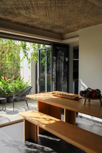a wooden table in a room with a large window at Ozonicia Residence Maikhao Phuket in Phuket
