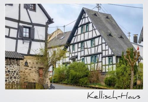 a large white and black house with at Ferien im Kellisch-Haus in Schalkenmehren