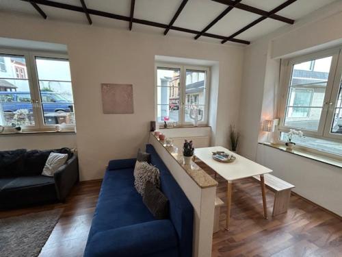 a living room with a blue couch and a table at Rheingold inklusive einer Flasche Sekt in Koblenz