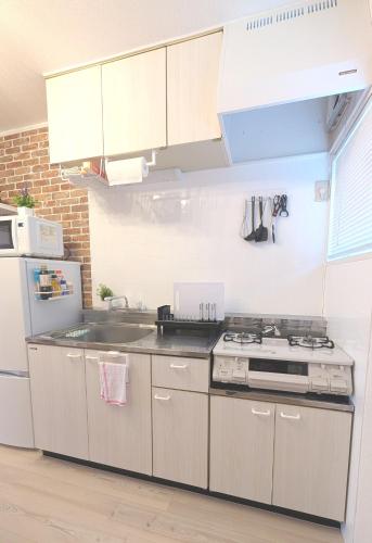 a kitchen with white cabinets and a stove top oven at 17min byCarTo Nagoya-Sta RoomB206 1parking Max5 Guest in Chiharachō
