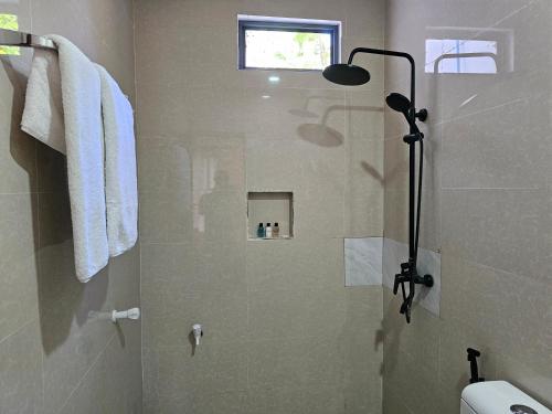 a bathroom with a shower with a glass door at Garden Rooms by Shams Thoddoo in Thoddoo