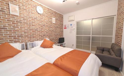 a bedroom with a large bed and a brick wall at 17min byCarTo Nagoya-Sta RoomB206 1parking Max5 Guest in Chiharachō