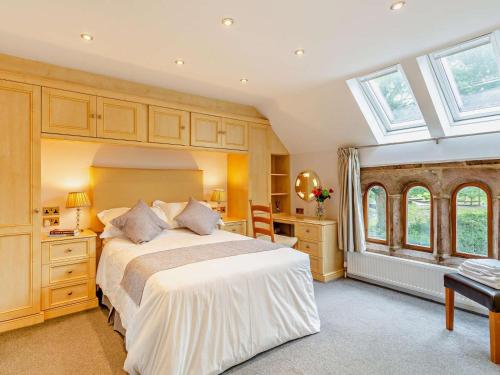 a bedroom with a large white bed and windows at 3 Bed in Harrogate oc-93305 in Summer Bridge