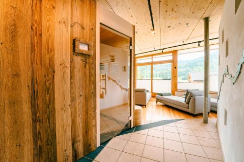 a living room with wooden walls and a couch at Arlbergerhof Vital in Weissensee