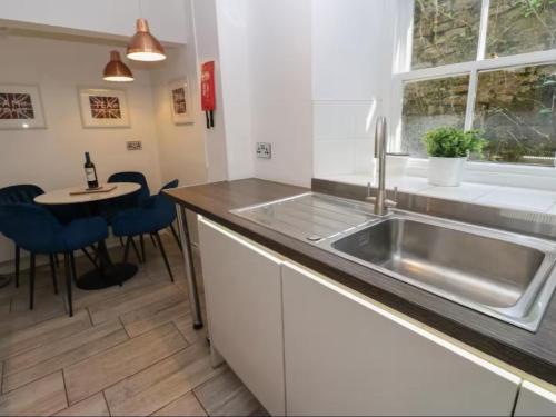 a kitchen with a sink and a table at Bumblebee Cottage, Aysgarth Falls in Aysgarth