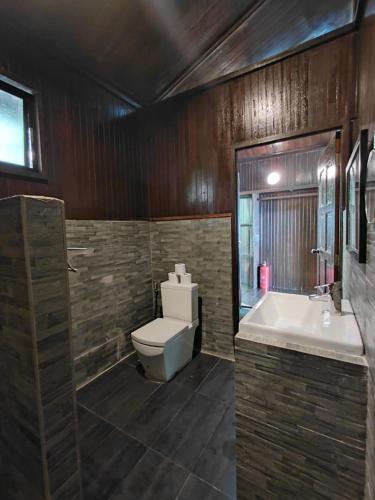 a bathroom with a toilet and a tub and a sink at Melina Beach Resort in Tioman Island