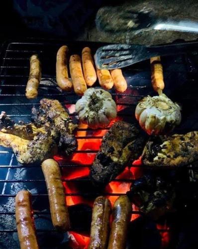 a grill with meat and sausages and other foods at narangala skycamping in Bokanoruwa