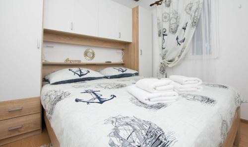 a bedroom with a bed with towels on it at House Sage in Tkon