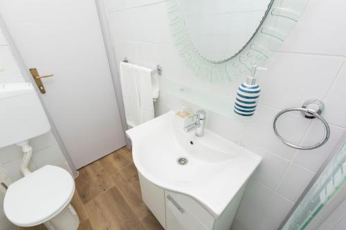 a bathroom with a white sink and a mirror at House Sage in Tkon