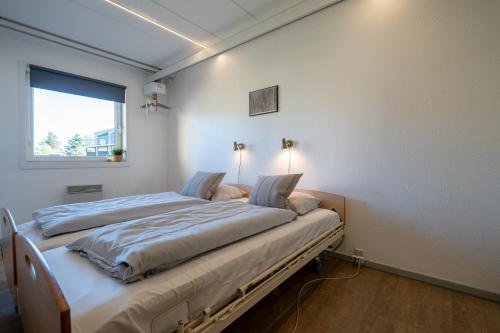 two beds in a room with a window at Feriecenter Slettestrand in Fjerritslev
