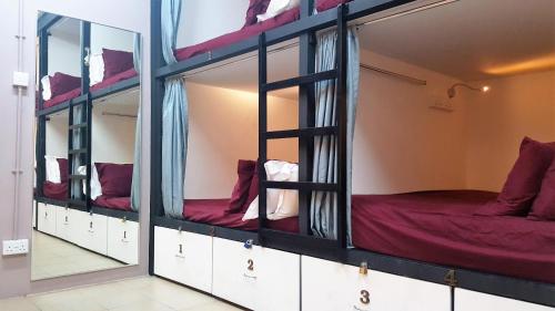 a group of bunk beds in a room with mirrors at Meadows Hostel in Singapore