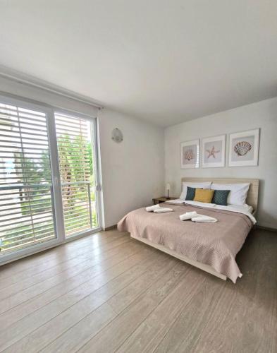 a bedroom with a large bed and a large window at Bella Vista Blu apartman s pogledom na more, Povljana, otok Pag in Povljana