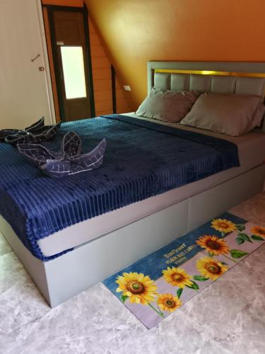 a bed with a blue comforter and flowers on it at mist valley in Ban Nong Chaeng