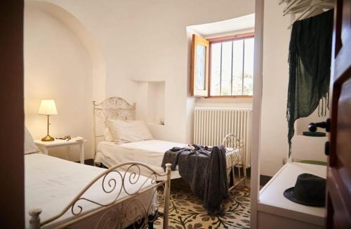 a small bedroom with two beds and a window at Trullo Dei Fiori in Cisternino