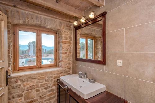 a bathroom with a sink and a mirror at Villa Miranda Hvar in Stari Grad